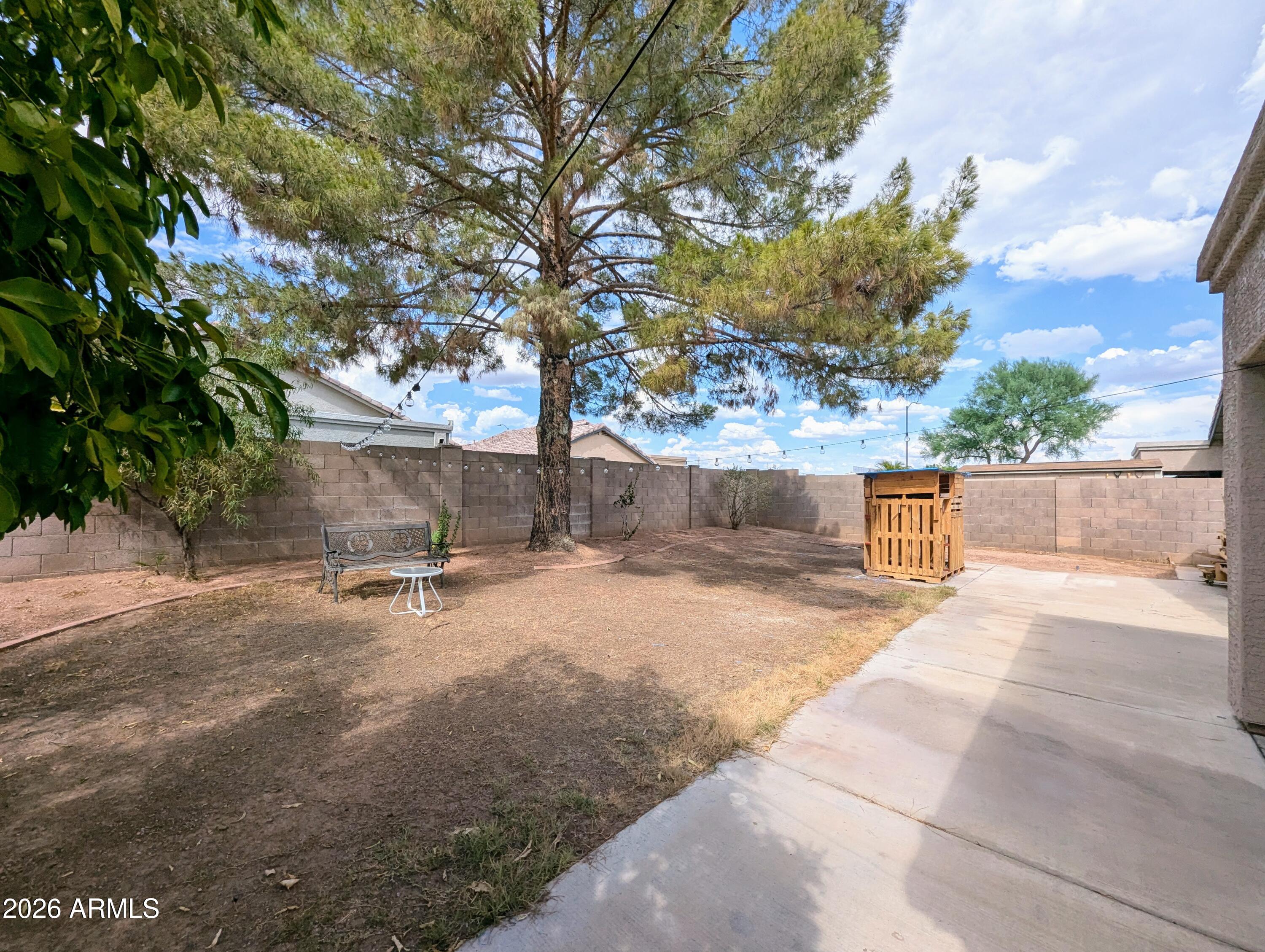 5424 West Wagoner Road Glendale, AZ 85308 - Photo 32 of 37 a backyard of a house with table and chairs under a large tree