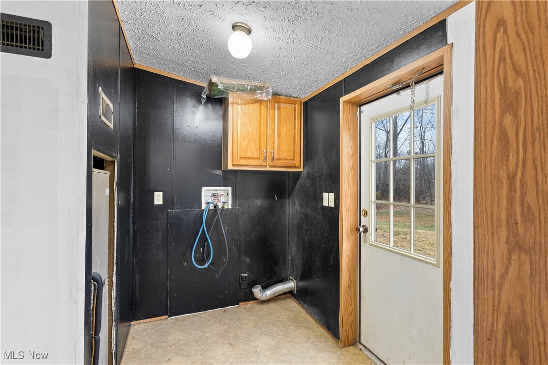 12859 Narrows Road Cambridge, OH 43725 - Photo 17 of 29 Laundry room featuring cabinets, washer hookup, and a textured ceiling