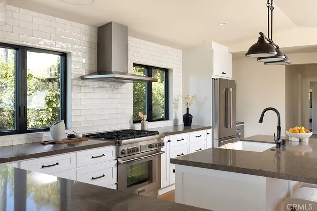 a kitchen with granite countertop a sink stainless steel appliances and a window