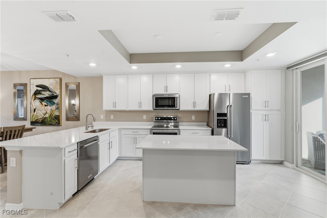 44000 Boardwalk Loop, Unit 1312 Punta Gorda, FL 33982 - Photo 18 of 48 a large kitchen with stainless steel appliances and white cabinets