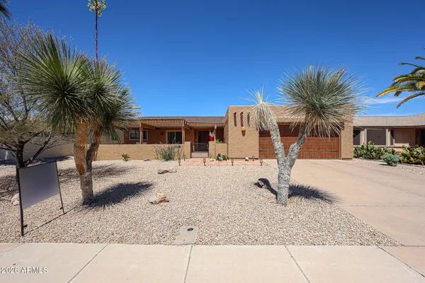a view of a house with backyard and a tree