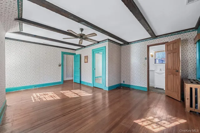 a view of an empty room with wooden floor