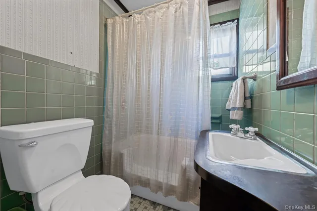 a bathroom with a sink a toilet a mirror and shower