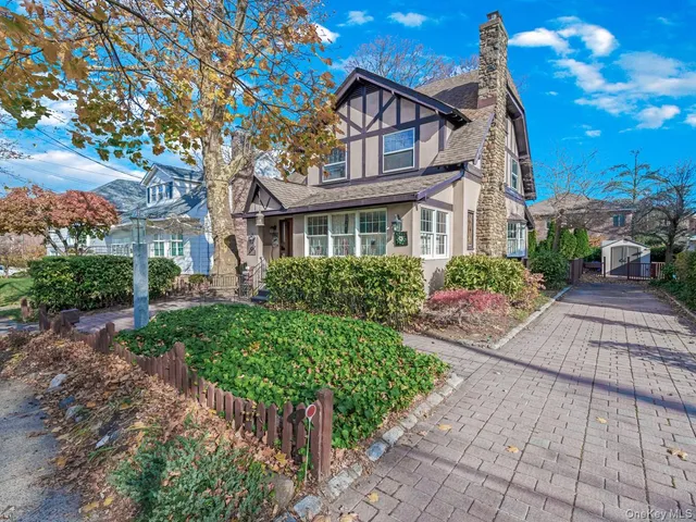 a front view of a house with a yard and potted plants