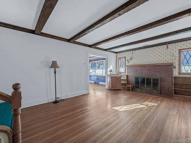 a view of empty room with wooden floor and fireplace