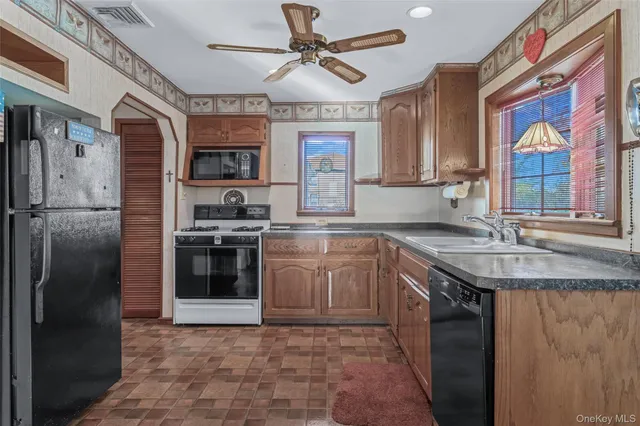 a kitchen with stainless steel appliances granite countertop a sink a stove a refrigerator and a granite counter tops with a view of living room