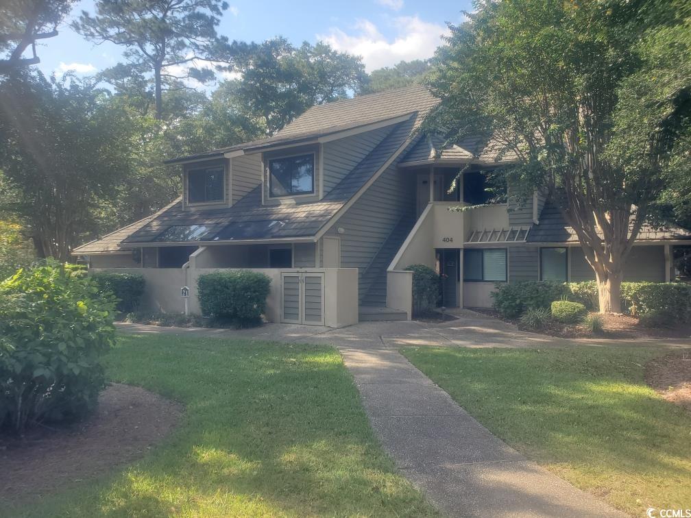 View of front of home with a balcony and a front lawn