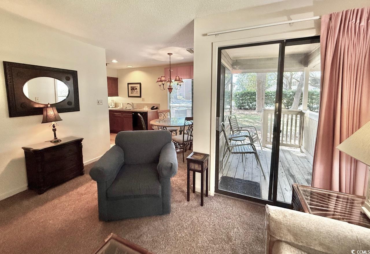 404 Melrose Place, Unit 21A Myrtle Beach, SC 29572 - Photo 11 of 30 Doorway to outside with carpet flooring, a textured ceiling, a chandelier, and recessed lighting