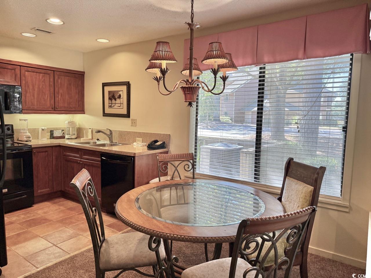 404 Melrose Place, Unit 21A Myrtle Beach, SC 29572 - Photo 12 of 30 Dining room with a chandelier, a textured ceiling, recessed lighting, and light tile patterned floors