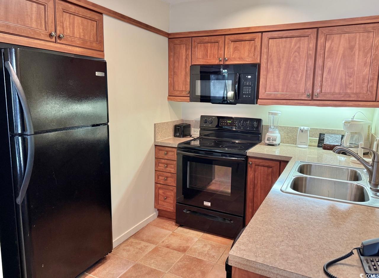 404 Melrose Place, Unit 21A Myrtle Beach, SC 29572 - Photo 16 of 30 Kitchen featuring black appliances, brown cabinets, and light countertops