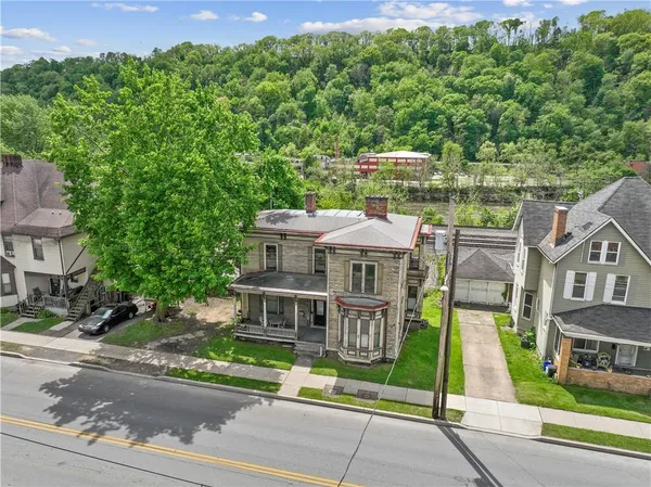 a view of a brick house with a yard and plants