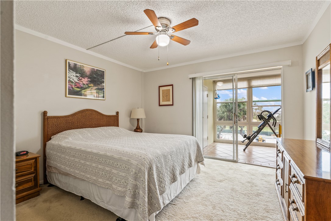 275 Date Palm Road, Unit 403 Vero Beach, FL 32963 - Photo 17 of 35 a bedroom with a large bed and a chandelier