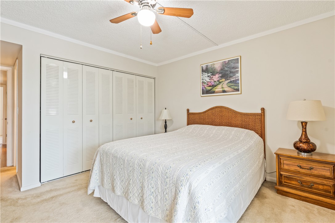 275 Date Palm Road, Unit 403 Vero Beach, FL 32963 - Photo 18 of 35 a spacious bedroom with a bed and a chandelier