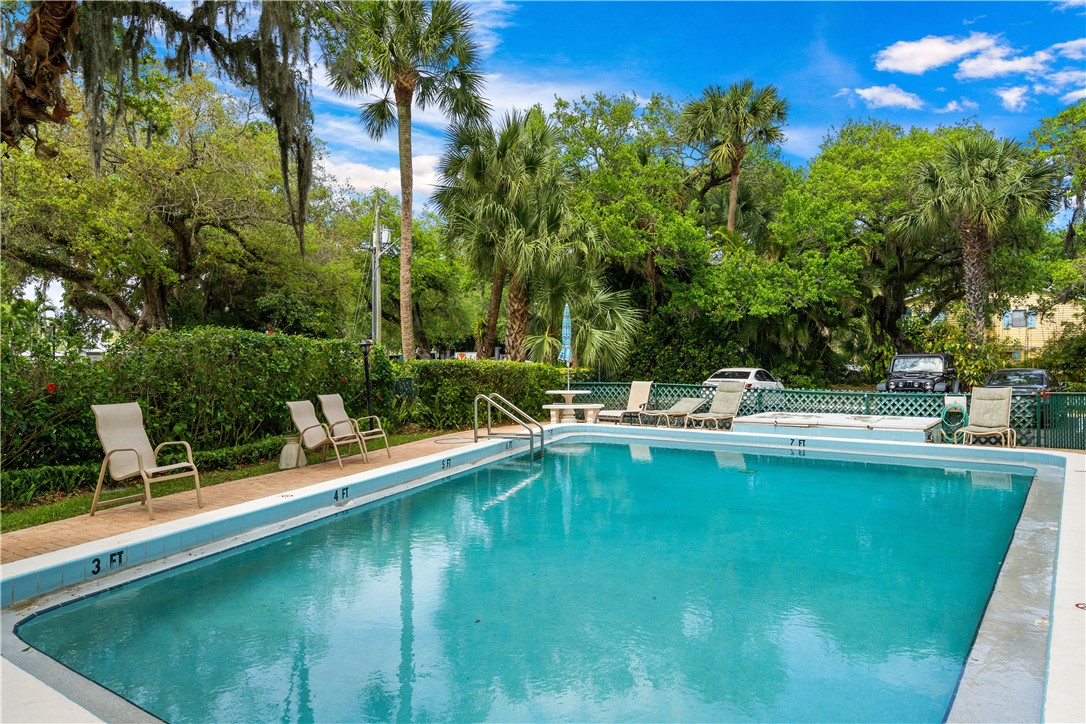 275 Date Palm Road, Unit 403 Vero Beach, FL 32963 - Photo 25 of 35 a view of a swimming pool with a table and chairs