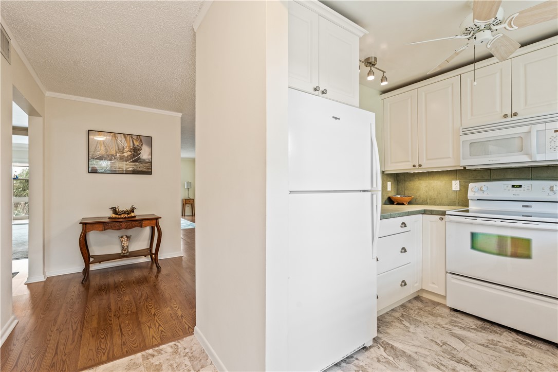 275 Date Palm Road, Unit 403 Vero Beach, FL 32963 - Photo 8 of 35 a kitchen with a refrigerator and cabinets