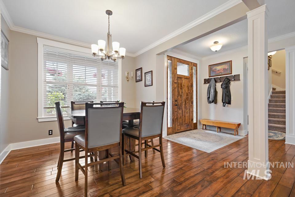 8271 Washoe Road Fruitland, ID 83619 - Photo 11 of 29 Dining area featuring hardwood-finish flooring, a multi-pane window with white blinds, and an overhead chandelier