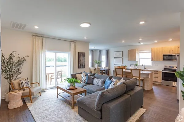 a living room with furniture wooden floor and a large window