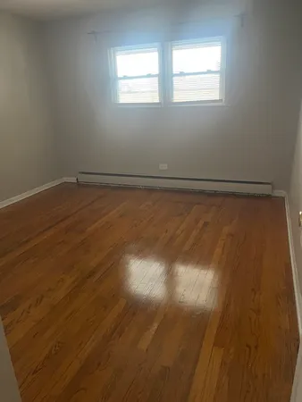 a view of a room with wooden floor and windows