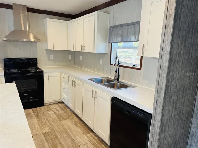 a kitchen with a sink dishwasher a stove and a refrigerator with wooden floor