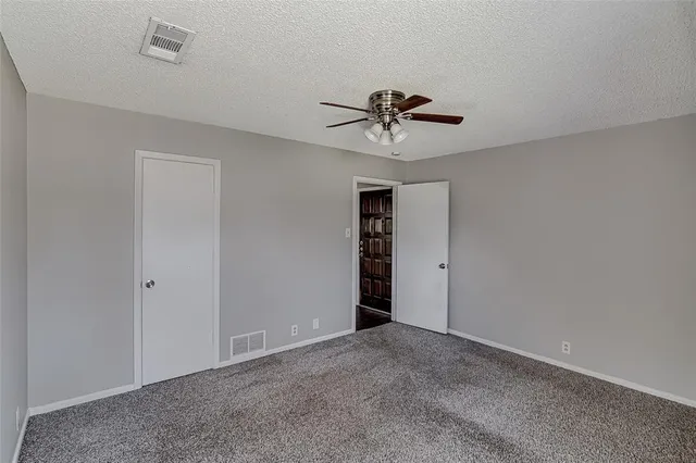 a view of an empty room with a ceiling fan