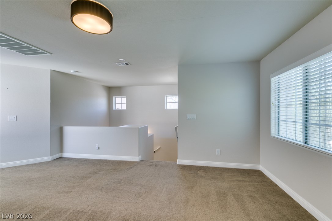 8909 Houston Ridge Avenue Las Vegas, NV 89178 - Photo 28 of 45 A spacious upper-level area, ideal for a flexible living space, features plush carpet and ample natural light.