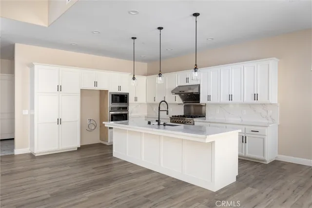 a kitchen with stainless steel appliances kitchen island a cabinets and wooden floor