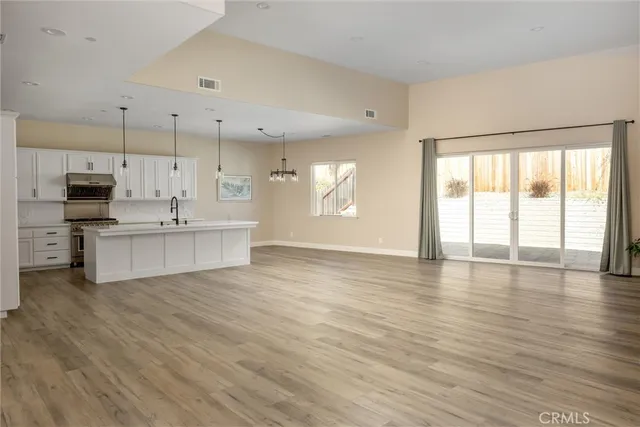 a big room with wooden floor and windows