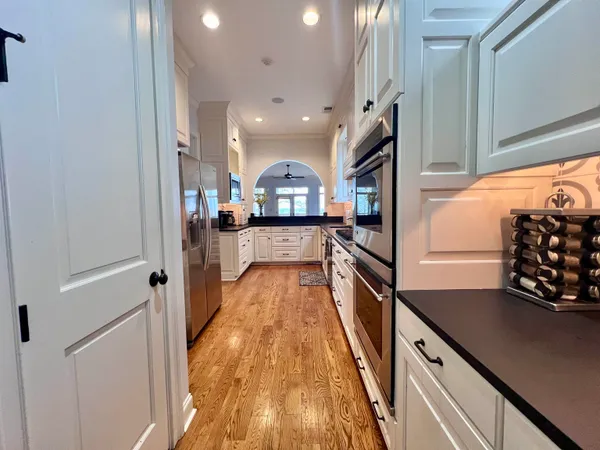 a kitchen with stainless steel appliances granite countertop a refrigerator a stove and a sink
