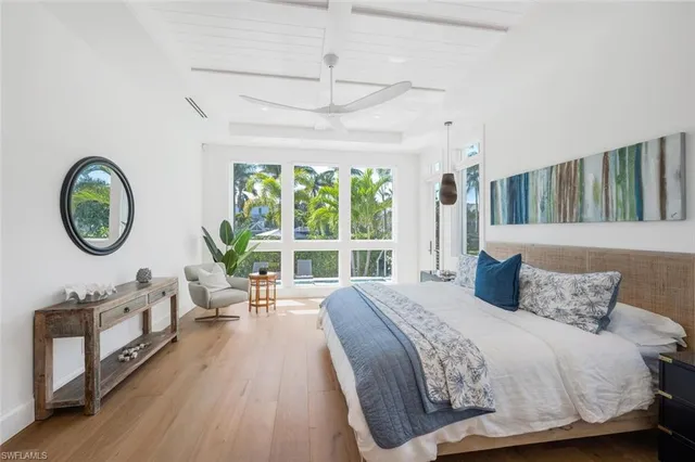 a bedroom with a bed a mirror and table