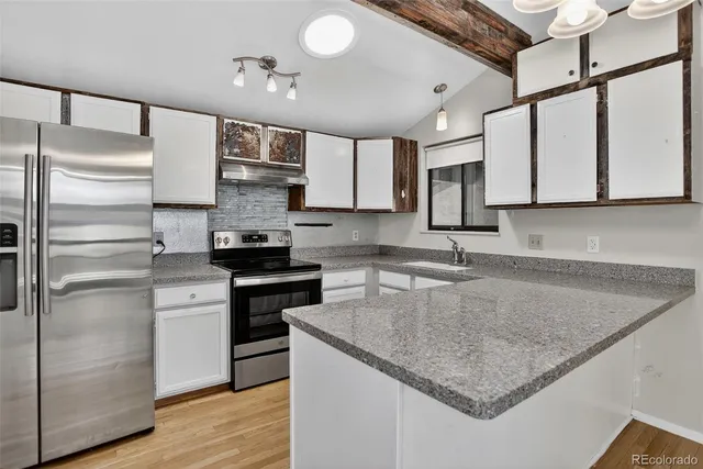 a kitchen with stainless steel appliances granite countertop a sink stove and refrigerator