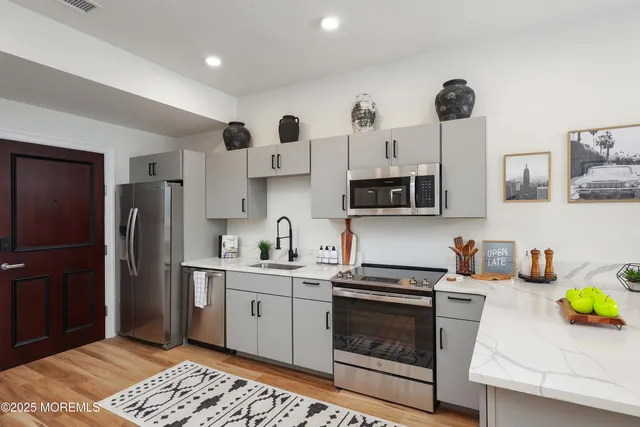 a kitchen with stainless steel appliances a stove a sink and a refrigerator