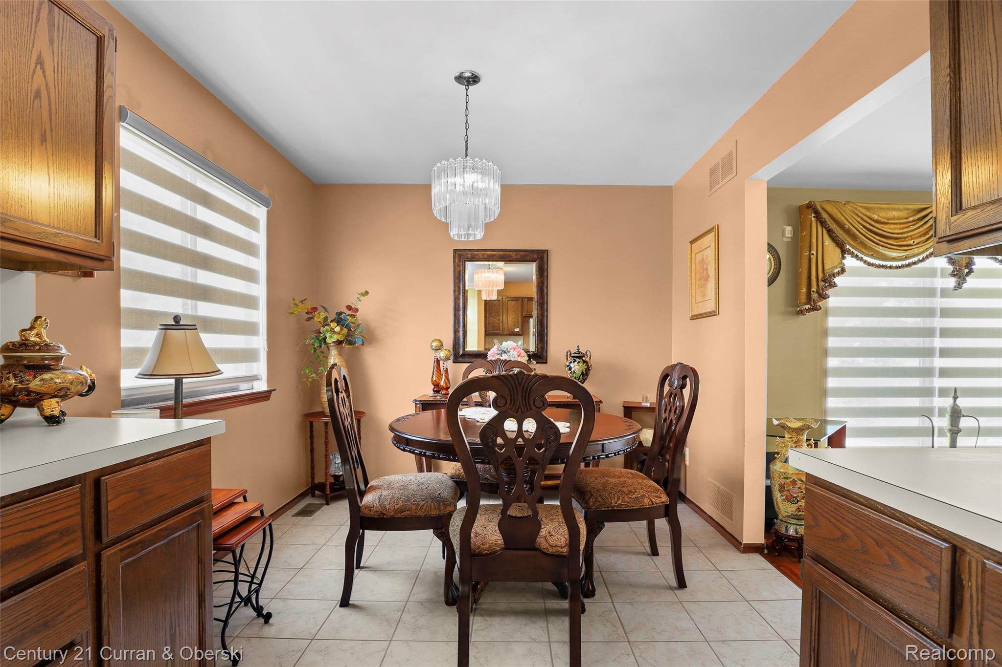 Dining area featuring tile flooring, a window with horizontal blinds, and a built-in ceiling light fixture