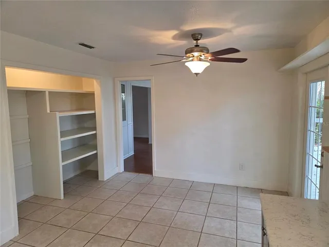 a kitchen with a refrigerator and white cabinets