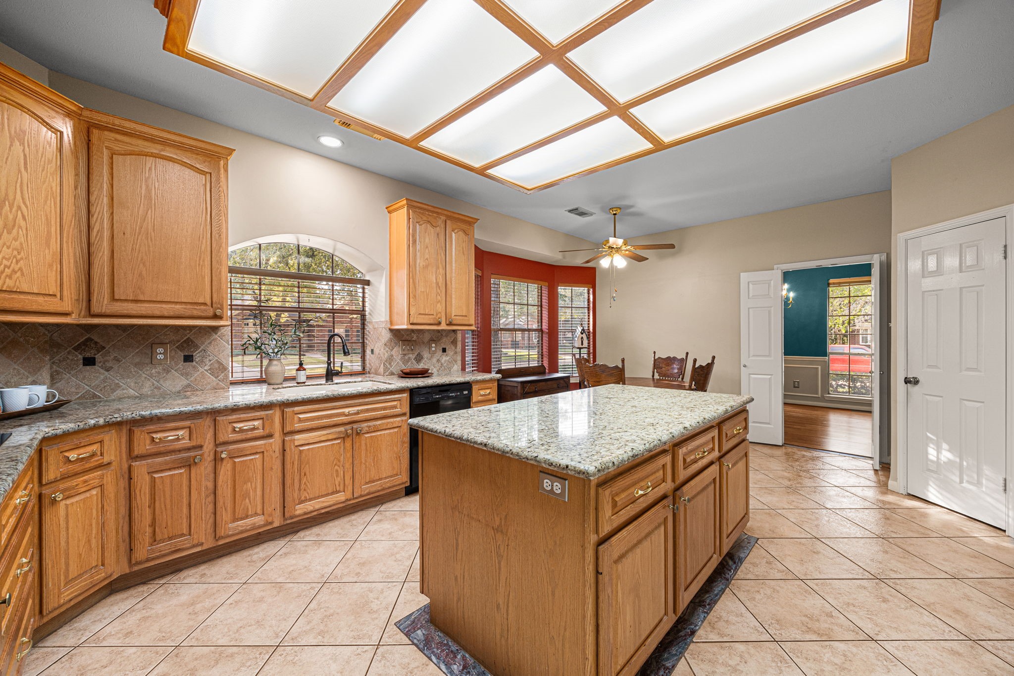 1102 Wood Fern Drive Sugar Land, TX 77479 - Photo 23 of 43 a kitchen with stainless steel appliances granite countertop a sink counter space cabinets and a large window