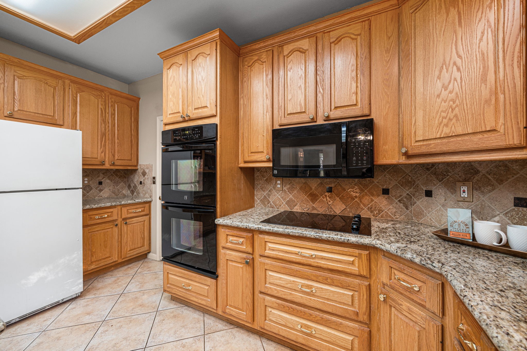 1102 Wood Fern Drive Sugar Land, TX 77479 - Photo 24 of 43 a kitchen with granite countertop stainless steel appliances a stove a sink and a refrigerator