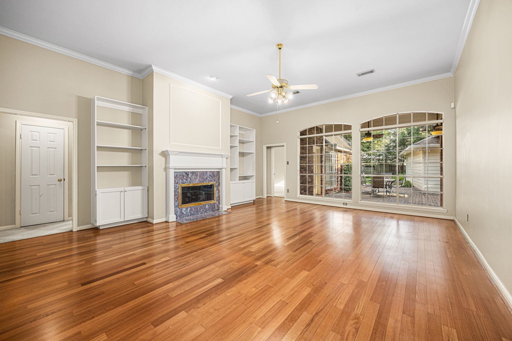 1102 Wood Fern Drive Sugar Land, TX 77479 - Photo 6 of 43 an empty room with wooden floor fireplace and windows