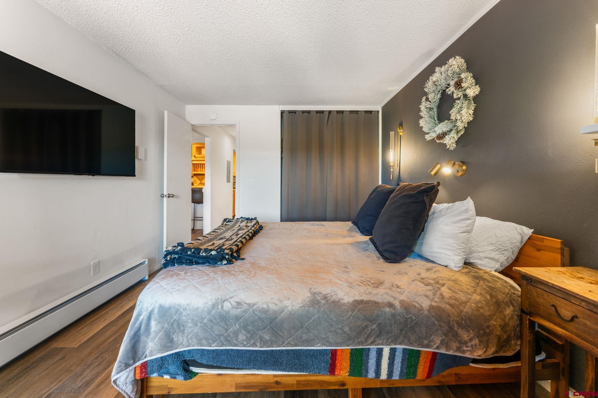 72 Hunter Hill Road, Unit I204 Crested Butte, CO 81225 - Photo 18 of 44 a bedroom with a large bed and a tv