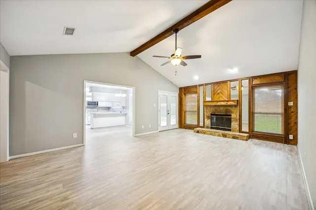 a view of an empty room with glass door and a window