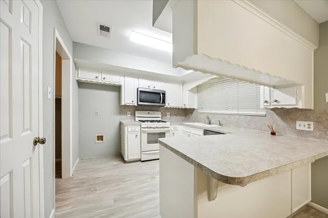 a kitchen with a sink a stove top oven and refrigerator