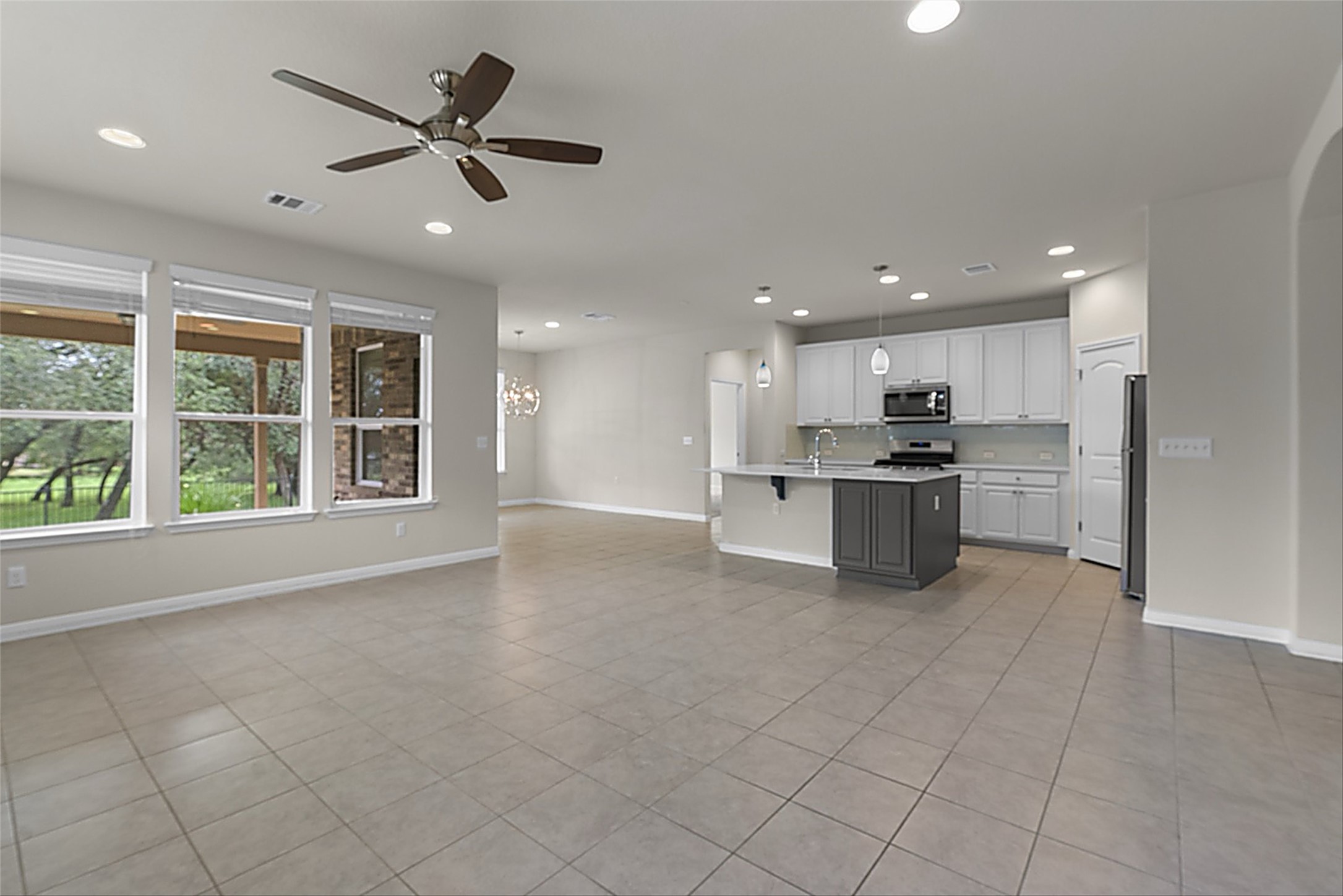 108 Calhoun Lane Georgetown, TX 78633 - Photo 8 of 32 an empty room with windows and kitchen view