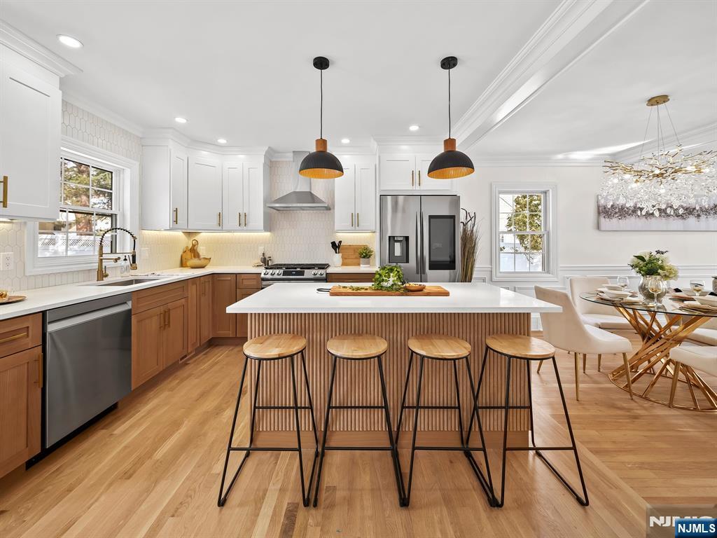 857 Collingwood Avenue Maywood, NJ 07607 - Photo 11 of 30 a kitchen with stainless steel appliances kitchen island granite countertop a table chairs in it and wooden floors
