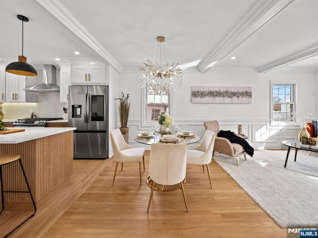 857 Collingwood Avenue Maywood, NJ 07607 - Photo 10 of 30 a view of a dining room and livingroom with furniture wooden floor a chandelier
