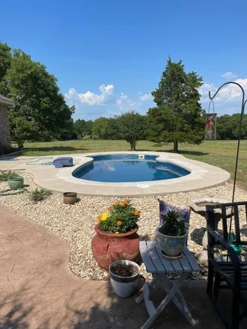 a view of a backyard with table and chairs under an umbrella