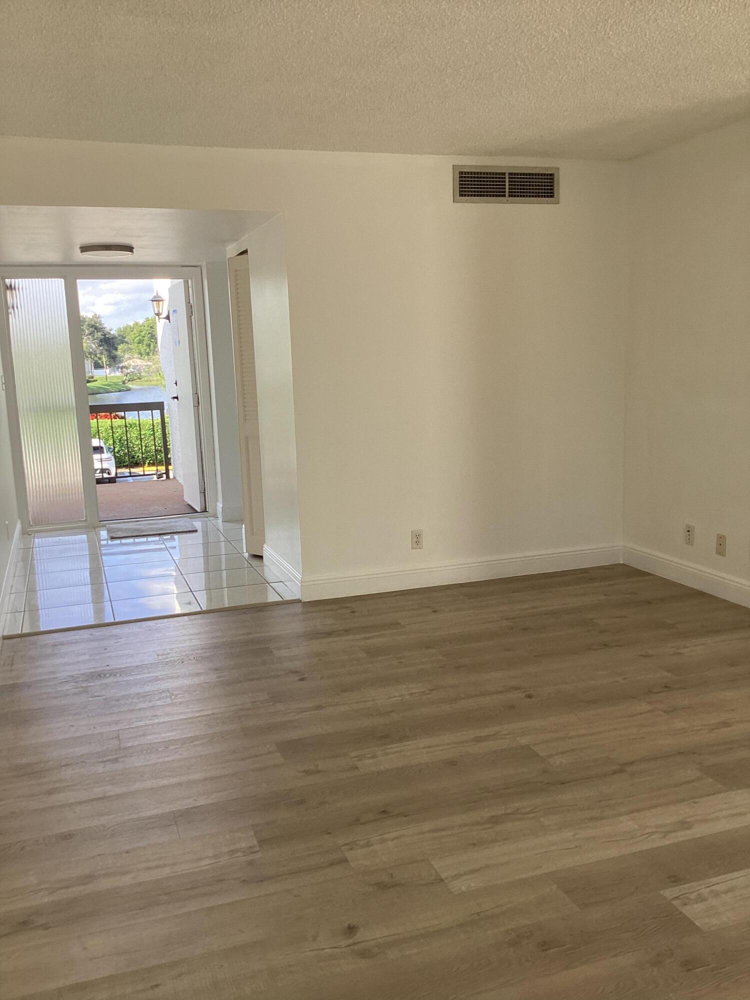 2308 Bridgewood Drive, Unit 2308 Boca Raton, FL 33434 - Photo 11 of 42 a view of an empty room with wooden floor and a window