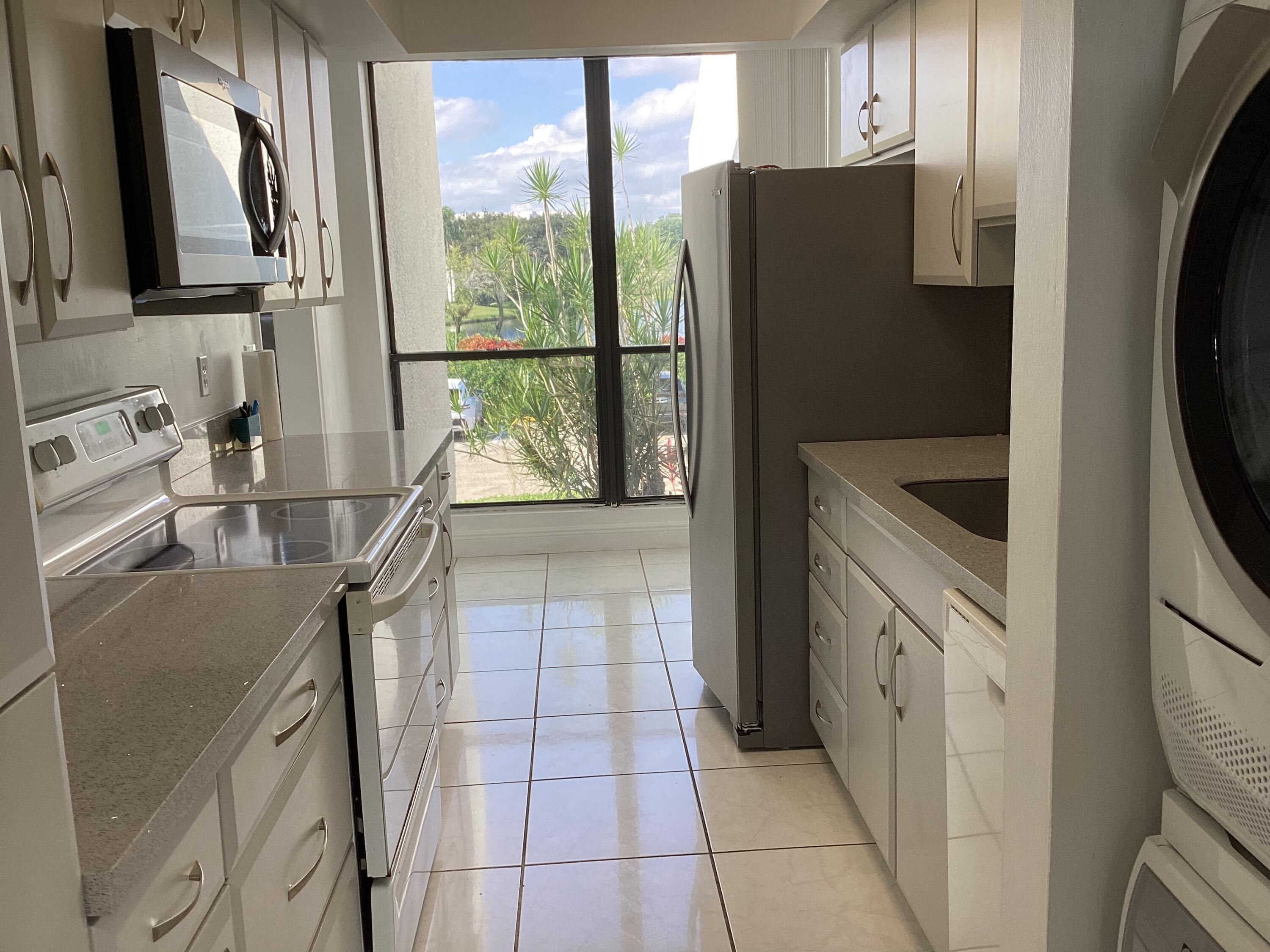 2308 Bridgewood Drive, Unit 2308 Boca Raton, FL 33434 - Photo 13 of 42 a kitchen with stainless steel appliances granite countertop a refrigerator and a sink