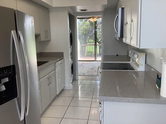 a kitchen with stainless steel appliances granite countertop a refrigerator and a sink
