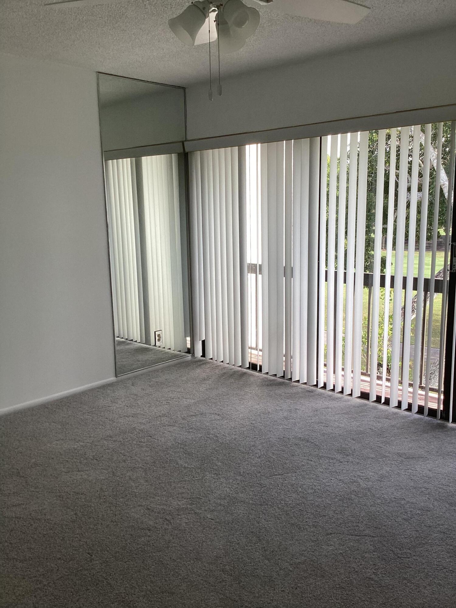 2308 Bridgewood Drive, Unit 2308 Boca Raton, FL 33434 - Photo 17 of 42 an empty room with windows and stairs