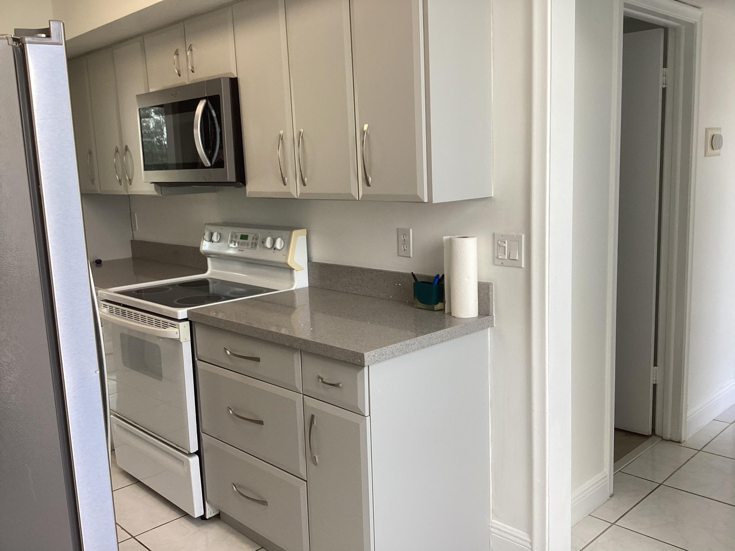 2308 Bridgewood Drive, Unit 2308 Boca Raton, FL 33434 - Photo 18 of 42 a kitchen with cabinets and stainless steel appliances
