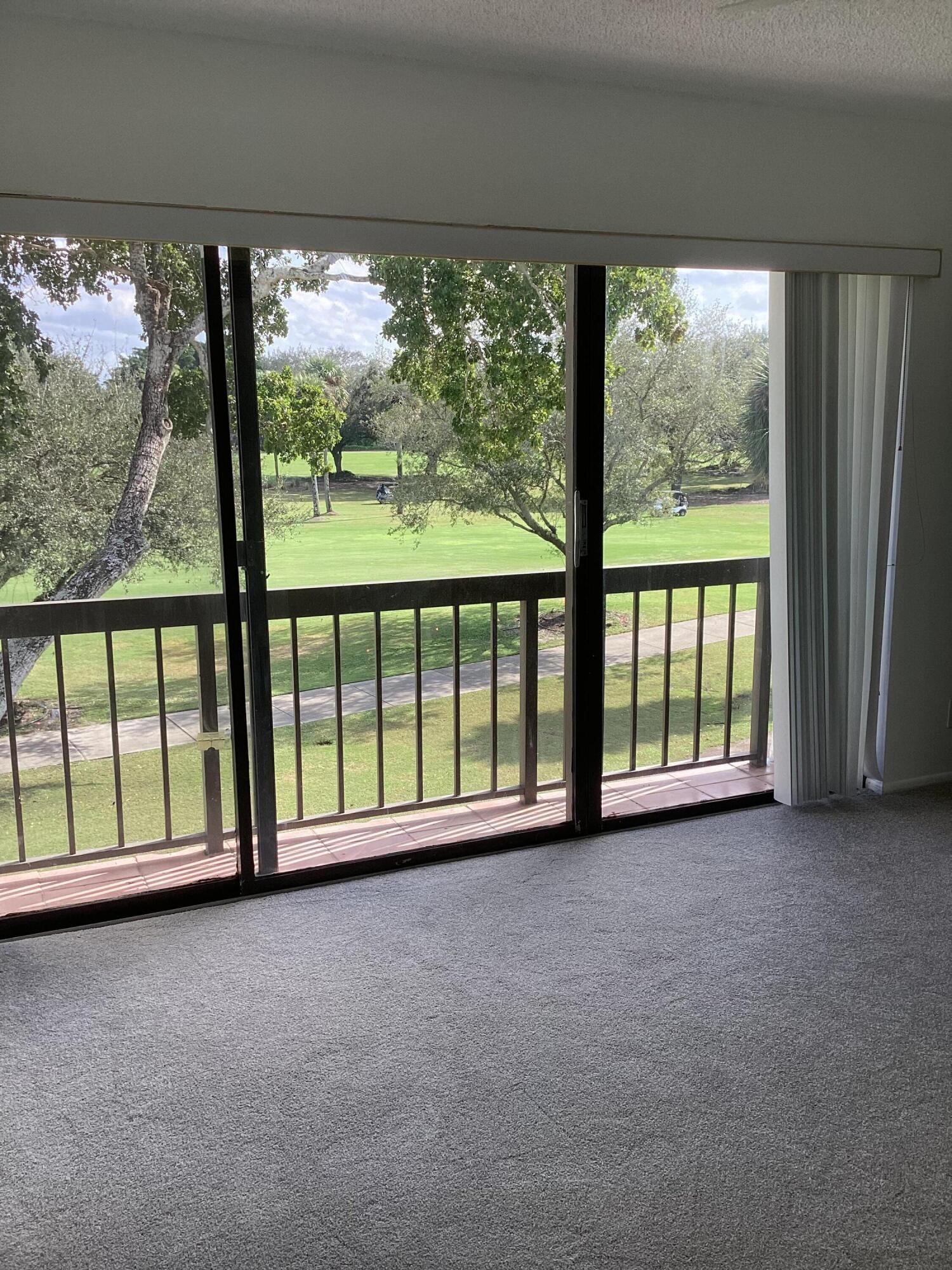2308 Bridgewood Drive, Unit 2308 Boca Raton, FL 33434 - Photo 20 of 42 an empty room with large windows and city view