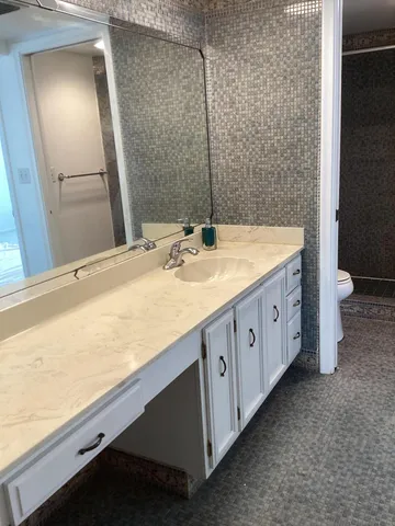 a bathroom with a granite countertop sink and a mirror
